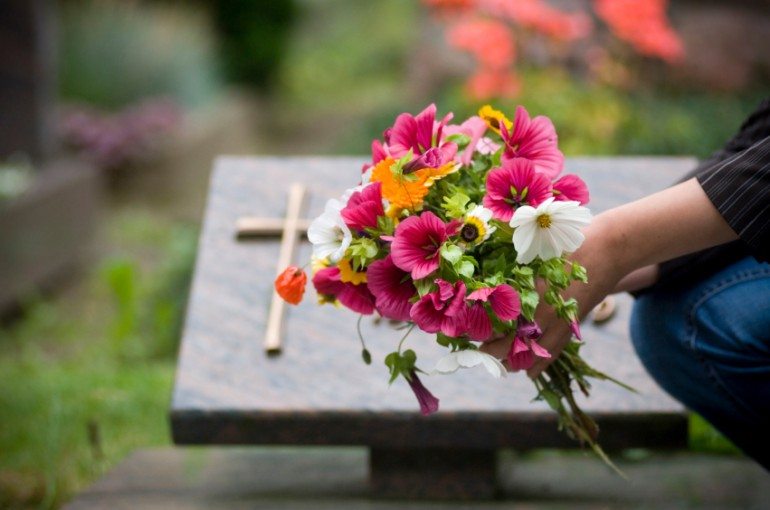 fleurs devant une tombe d'un cimetière